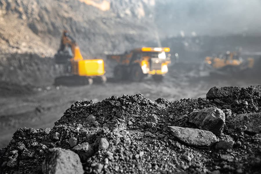 Brisbane sit-on mine dump truck at a construction site, large industrial heavy-duty machinery, used in excavation and mining operations, under clear blue sky.