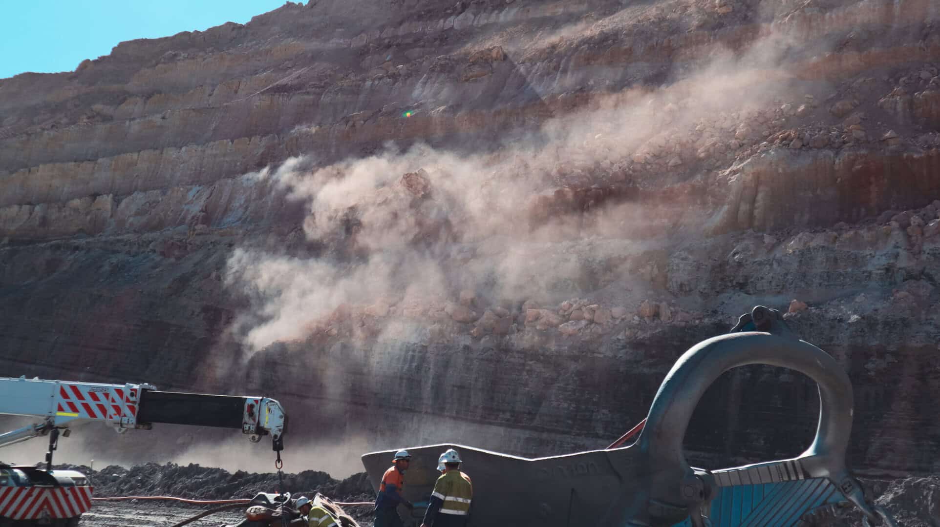 Brisbane sit-on mine dump truck at a construction site, large industrial heavy-duty machinery, used in excavation and mining operations, under clear blue sky.