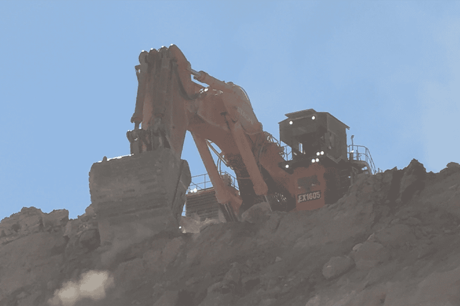Brisbane sit-on mine dump truck at a construction site, large industrial heavy-duty machinery, used in excavation and mining operations, under clear blue sky.