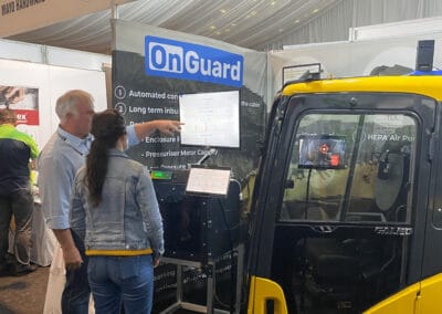 High-tech industrial ventilation and air purification systems at a trade show, featuring OnGuard air quality solutions for enhanced workplace safety and clean air management.