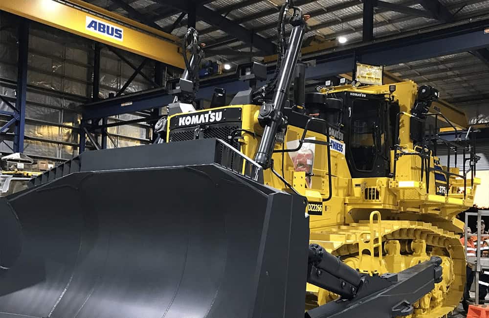 Komatsu construction equipment in warehouse with BreatheSafe air quality solutions in Australia.