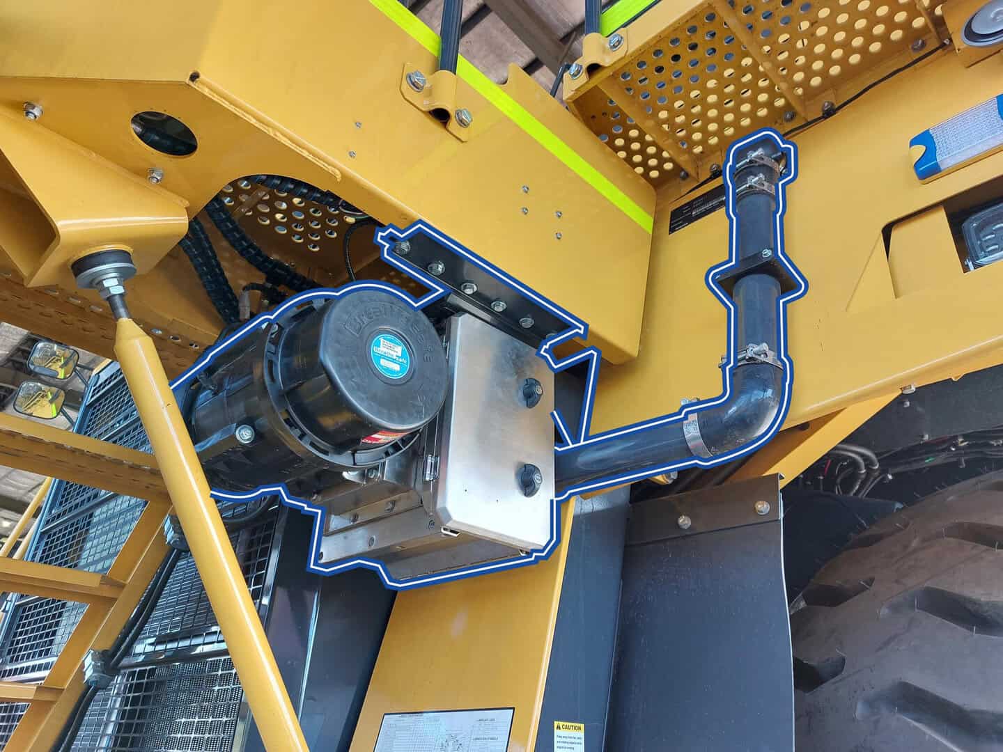 TL4 with ACF on Caterpillar 785D High-pressure hydraulic system with black hose and metal fittings on industrial yellow equipment, showcasing durable machinery components.