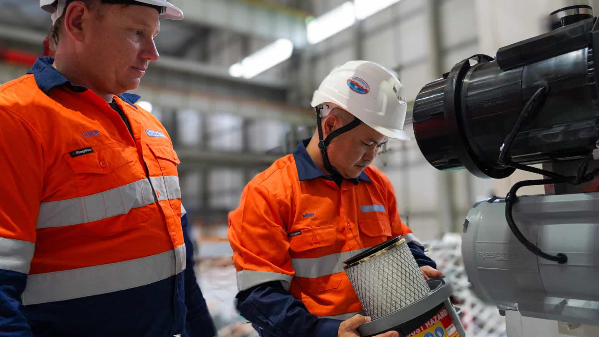 High-visibility workwear for industrial safety with respiratory protection at manufacturing plant in Australia.