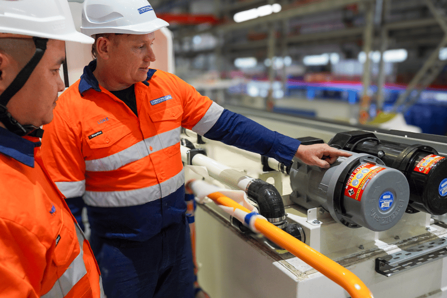 Industrial workers operating breathing-safe equipment in a manufacturing plant, promoting workplace respiratory safety and compliance with health standards.